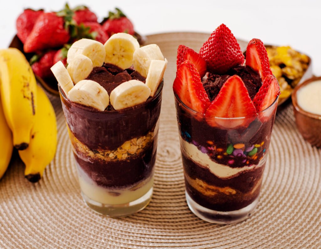 Imagem de dois copos de açaí. um com banana e outro com morango.